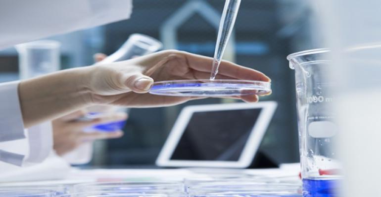 lab tech dropping liquid on a petri dish